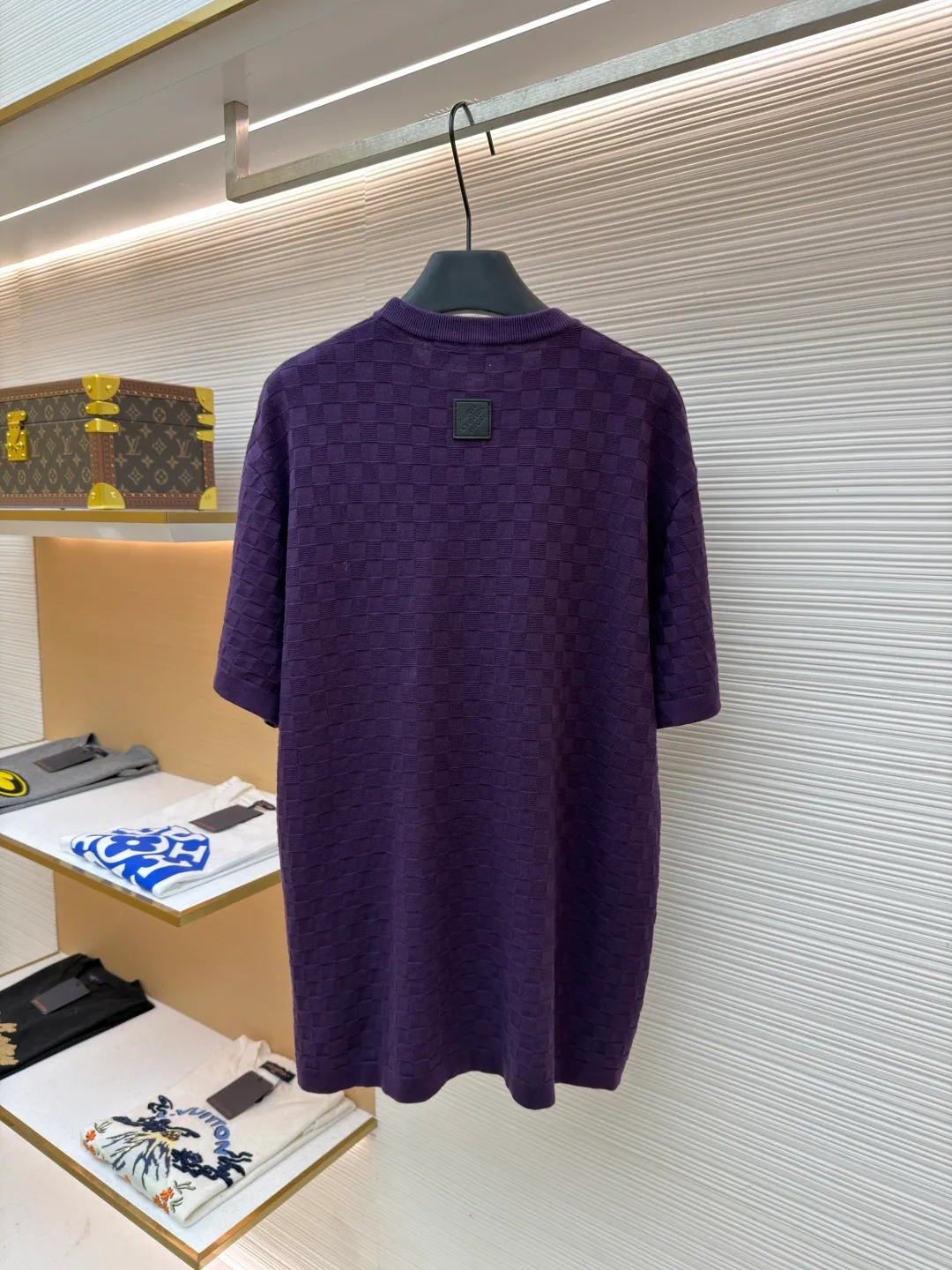 LOUIS VUITTON letter embroidered dark checkerboard jacquard short sleeves ●Original version: Purchased and developed at 9350 ●Item number: 1682319-B00 ●Fabric: 100% cotton ●Technology: jacquard knitting ●Color: Purple ●Version: Fitted version ●Weight: about 340 grams ●Size: S-M-L-XL ●Description: This Louis Vuitton purple knitted short-sleeve is made of custom worsted wool blended fabric. It is created with an 18-needle high-density weaving process using a computerized flat knitting machine to create a three-dimensional checkerboard texture. The checkered pattern is laser positioned and patterned. The size and spacing of each grid are accurate to 0.1 cm, showing a regular relief texture. The left chest uses same-color inlay embroidery technology, and the "LVM SINCE 1854" logo is embroidered with a high density of 1200 stitches/square centimeter. The embroidery thread is made of high-elastic mercerized cotton thread of the same color as the body, forming a natural texture layer with the knitted base. The neckline adopts seamless cylindrical rib technology, which is not easy to loose after high-temperature shaping treatment. The shoulders are made of seamless bonding technology to reduce the abruptness of the seams. The overall micro-profile tailoring combined with the invisible stitching technology of the side seams not only ensures the comfort of wearing, but also makes the body lines smoother. Each process has undergone multiple quality control tests by the brand to ensure the quality and durability of the craftsmanship. The overall wiring is straight and delicate, the fabric is comfortable and soft, and the color is consistent without color difference. It can be matched with the same style to create a fashionable look and control various occasions. Customized accessories, complete with three standards, same style for men and women!